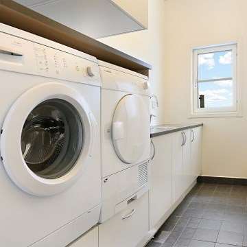 Bild på en tvättstuga med tvättmaskin och torktumlare