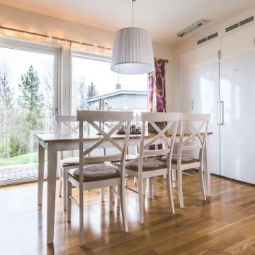 Bild på ett kök med köksbord och stolar