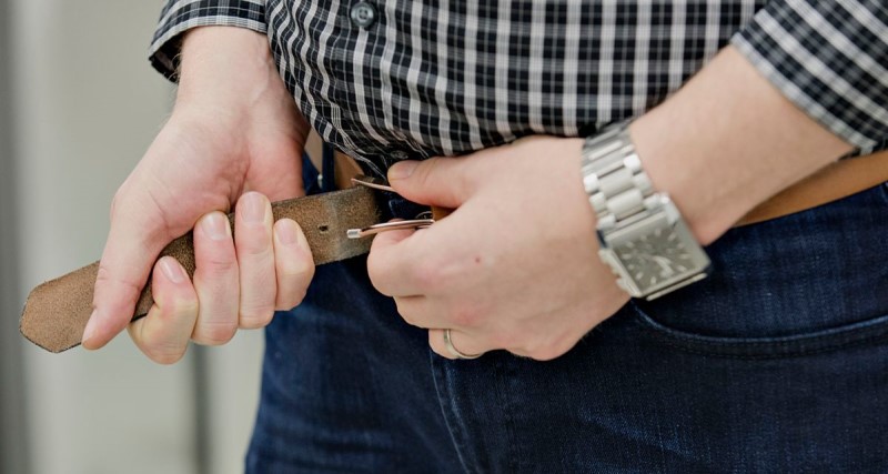 En person drar åt sitt bälte